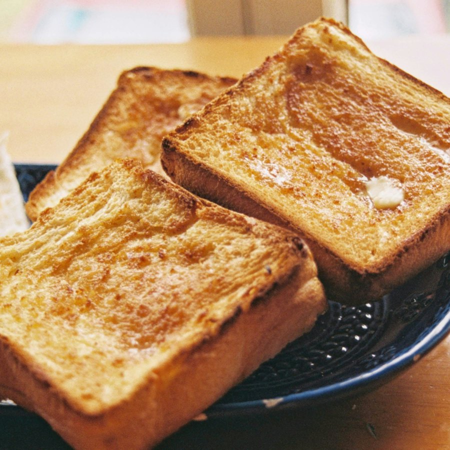 黒い皿にのせた焼きたてのトースト