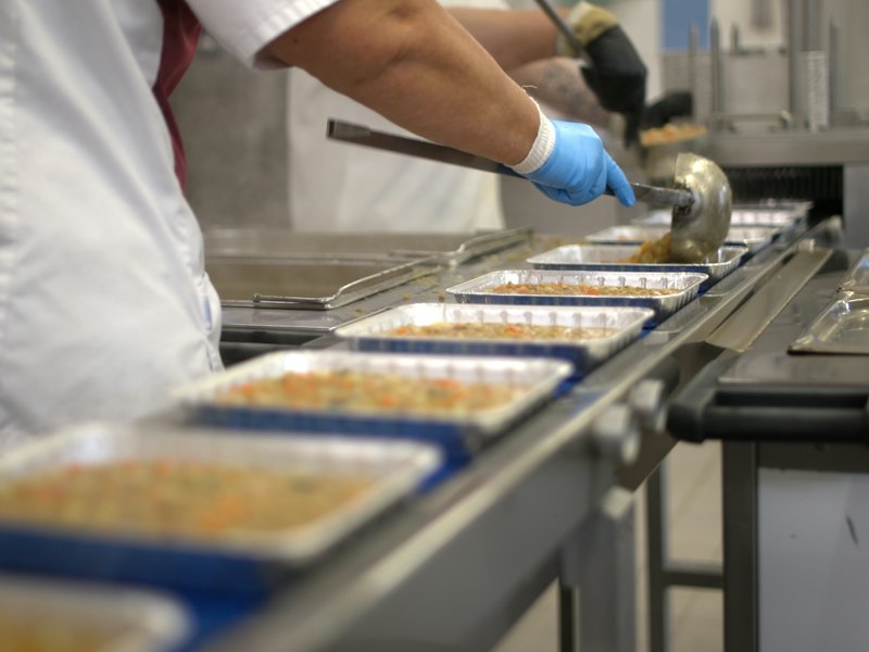 食品工場で製品をトレーに詰める作業の様子